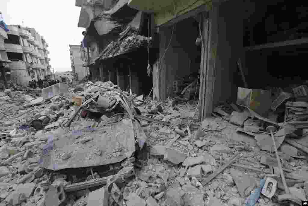 People inspect a damaged site after airstrikes on the town of Ariha, in Idlib province, Syria.