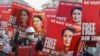 FILE - Demonstrators hold placards depicting deposed Myanmar leader Aung San Suu Kyi during a protest against the military coup, in Naypyitaw, Myanmar, Feb. 17, 2021.