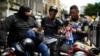 Un muñeco Super Bigote, inspirado en el presidente venezolano, Nicolás Maduro, está unido a una motocicleta de miembros de un grupo de motociclistas, conocido como Fuerza Motorizada, durante un ejercicio militar en Caracas, Venezuela, el 23 de enero de 2025. 