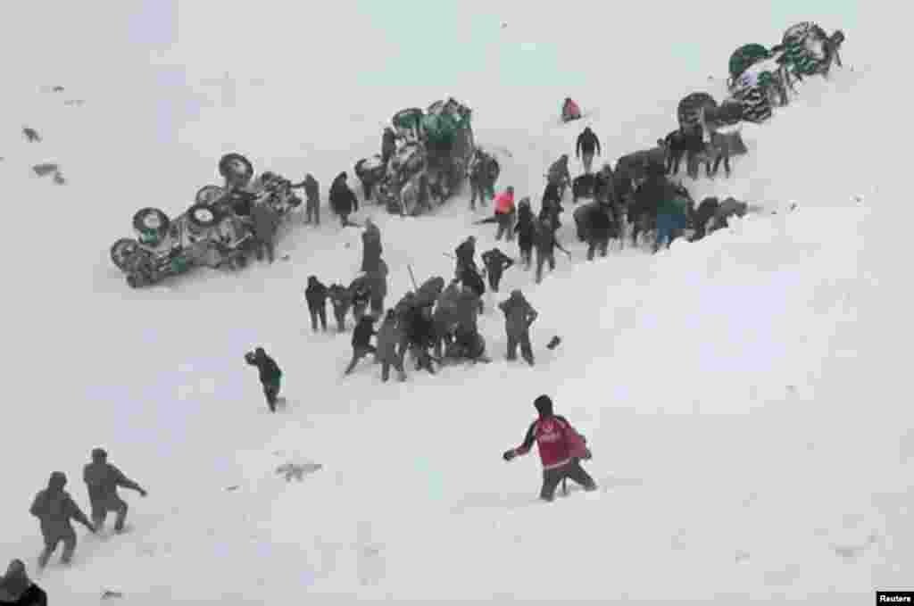Turkish soldiers and locals rescue people trapped under avalanche in Bahcesaray in Van province, Turkey, in this still image taken from video. (Credit: Ihlas News Agency)