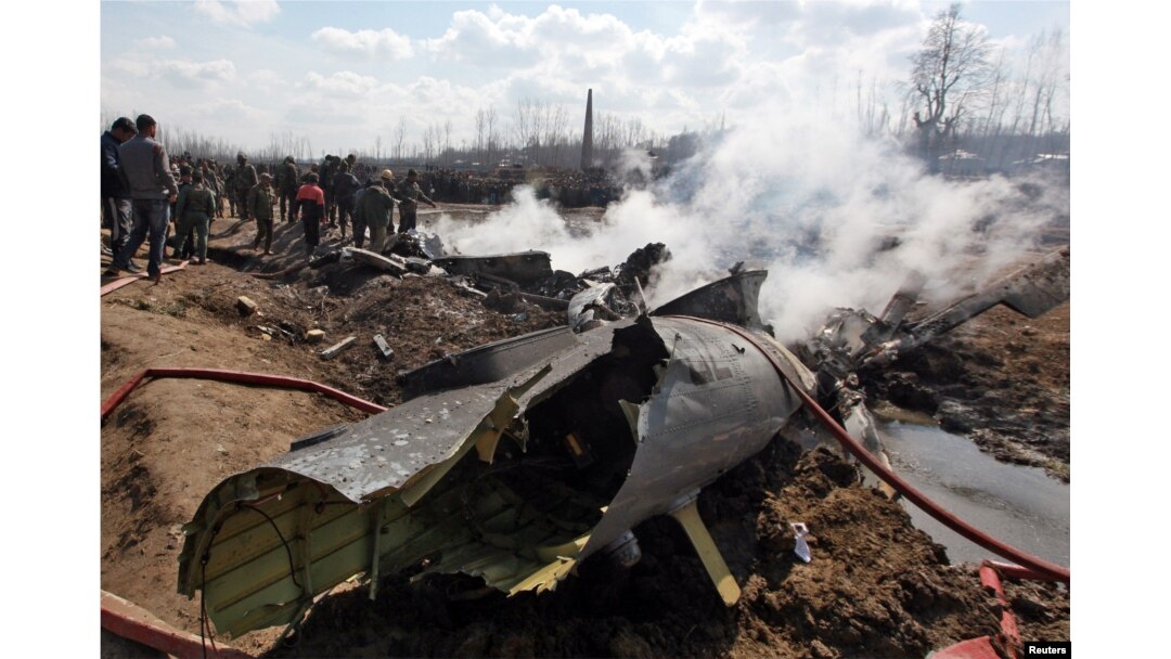 People stand next to the wreckage of Indian Air Force's helicopter after it crashed in Budgam district in Kashmir, Feb. 27, 2019.