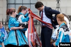 Canada's Prime Minister Justin Trudeau receives a traditional Metis sash during an event announcing the creation of a new space for Indigenous Peoples at 100 Wellington Street, across from Parliament Hill, in Ottawa, Ontario, Canada, June 21, 2017.