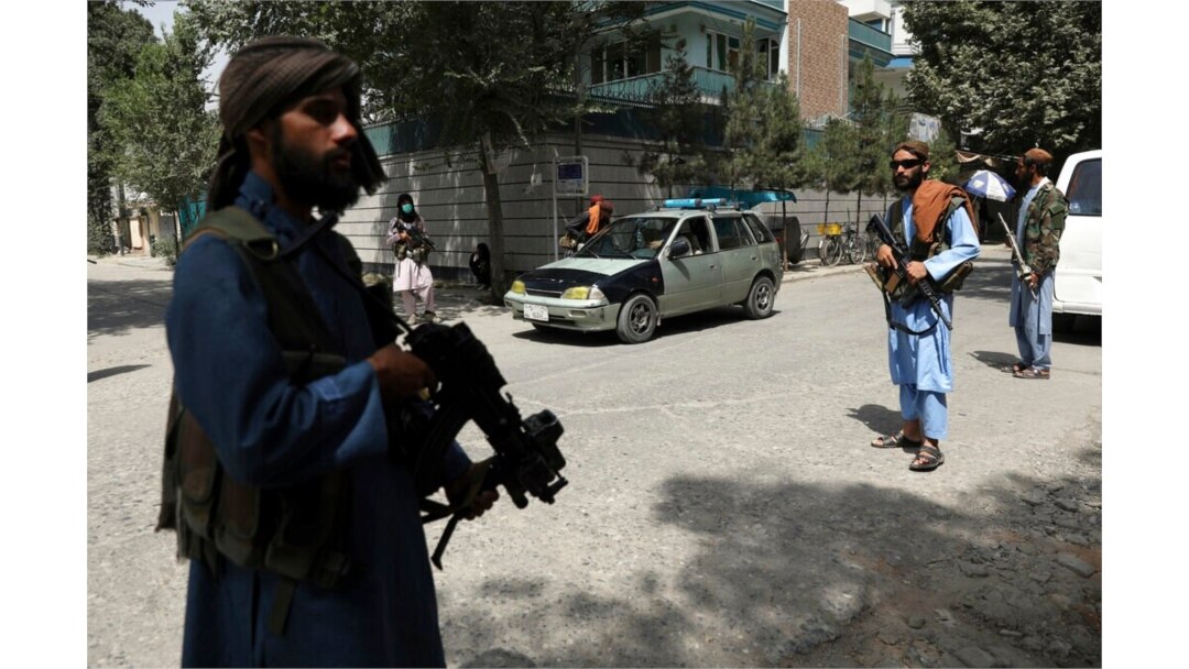 FILE - Taliban fighters stand guard at a checkpoint in the Wazir Akbar Khan neighborhood in the city of Kabul, Afghanistan, Aug. 18, 2021.