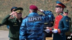 A photo provided by the Russian Defense Ministry shows Russian Defense Minister Sergei Shoigu (L) awarding a former Ukrainian special forces "Berkut" officer (back to camera) at a military base in Sevastopol, Crimea, March 24, 2014.