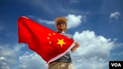 一位中国警察在西沙群岛上展示国旗（2014年9月14日）