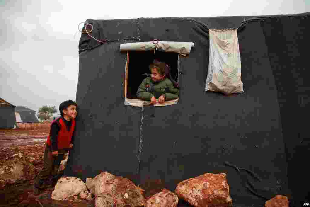 A boy and a girl exchange glances at a flooded camp for displaced Syrians near the village of Killi in the north of the northwestern Idlib province.