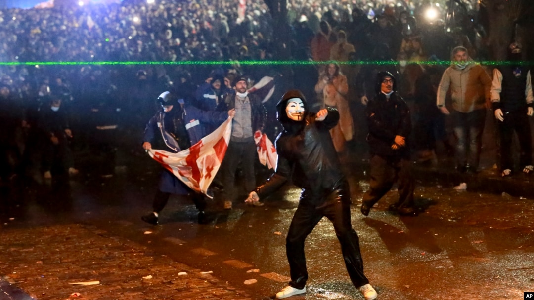 Un manifestante lanza un objeto hacia la policía durante una manifestación contra la decisión de los gobiernos de suspender las negociaciones para unirse a la Unión Europea durante cuatro años, frente al edificio del parlamento en Tbilisi, Georgia, el 1 de diciembre de 2024. AP