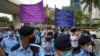 Police officers raise signs warning protesters outside West Kowloon Magistrates' Courts in Hong Kong, March 1, 2021.