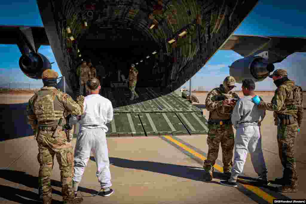 The first U.S. military aircraft to carry detained migrants whom U.S. Department of Homeland Security spokesperson Tricia McLaughlin called "highly dangerous criminal aliens," to a detention center at Guantanamo Bay, Cuba, is boarded from an unidentified site in the U.S. on February 4, 2025.