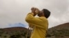 Kupono Mele-Ana-Kekua, 35, of Kaaaawa, Hawaii, blows a conch shell near the summit of Mauna Kea on Hawaii's Big Island, Monday, Aug. 31, 2015, protesting construction of the Thirty Meter Telescope.
