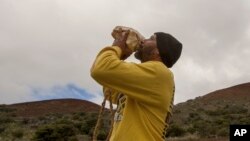 Kupono Mele-Ana-Kekua, 35, of Kaaaawa, Hawaii, blows a conch shell near the summit of Mauna Kea on Hawaii's Big Island, Monday, Aug. 31, 2015, protesting construction of the Thirty Meter Telescope.