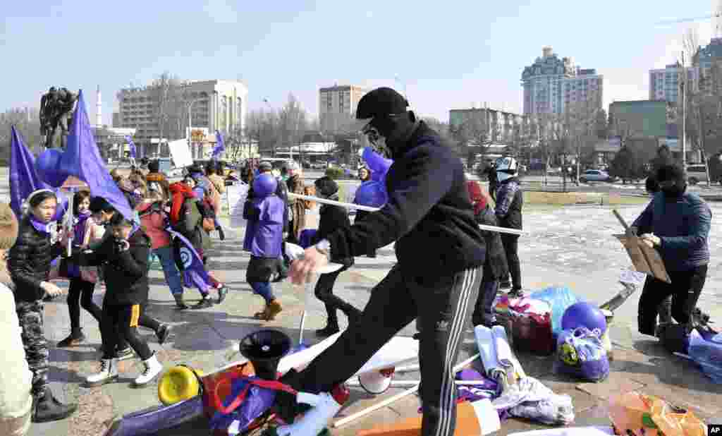 Masked Kyrgyz nationalists attack women's rights activists during the celebration of the International Women's Day at Victory Square in Bishkek, Kyrgyzstan.