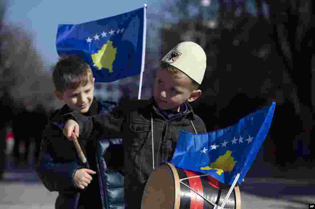 A boy plays on a drum decorated with Kosovo's flag to celebrate the 12th anniversary of the country's independence, in the capital Pristina.
