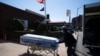 FILE - In this March 27, 2020, photo, William Samuels delivers caskets to the Gerard Neufeld Funeral Home during the coronavirus pandemic in the Queens borough of New York.