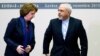 EU foreign policy chief Catherine Ashton (L) and Iranian Foreign Minister Mohammad Javad Zarif rise after a photo opportunity ahead of closed-door nuclear talks at the United Nations European headquarters in Geneva, Switzerland. Nov. 20, 2013.