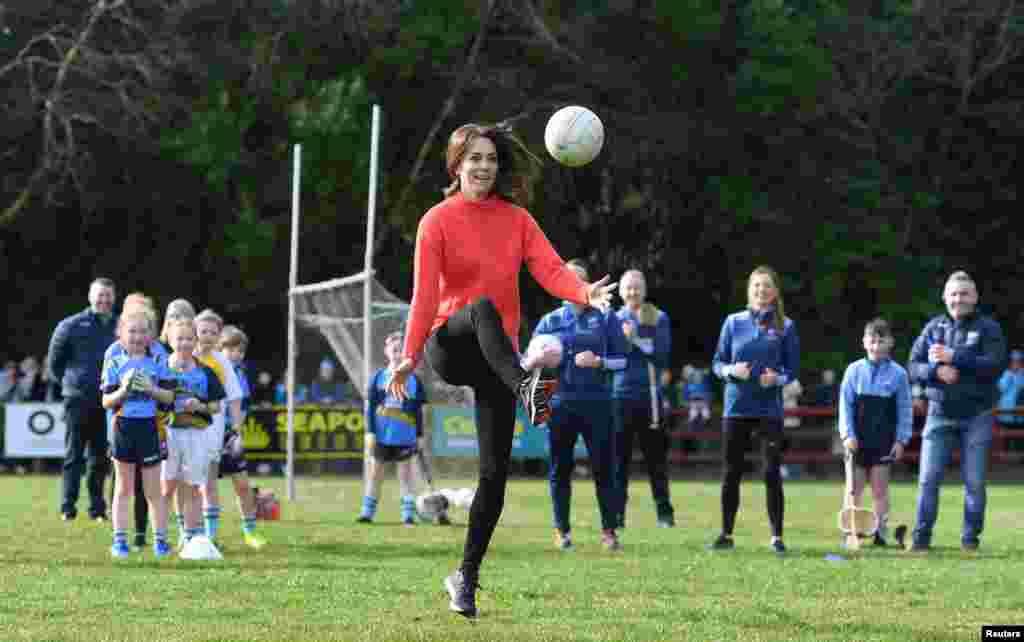 Britain's Catherine, Duchess of Cambridge reacts as she plays Gaelic football during a visit to the local Salthill Knocknacarra Gaelic Athletic Association Club (GAA) in Galway, Ireland.