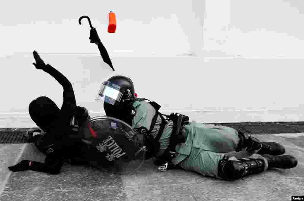 A riot police officer tries to subdue a protester during an anti-government demonstration in Hong Kong.