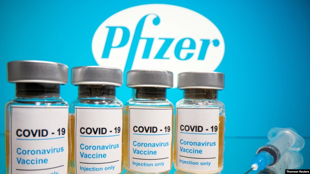 FILE PHOTO: Vials and medical syringe are seen in front of Pfizer logo in this illustration