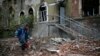 A local resident walks past buildings damaged by recent shelling in the eastern Ukrainian village of Semenovka, July 9, 2014.
