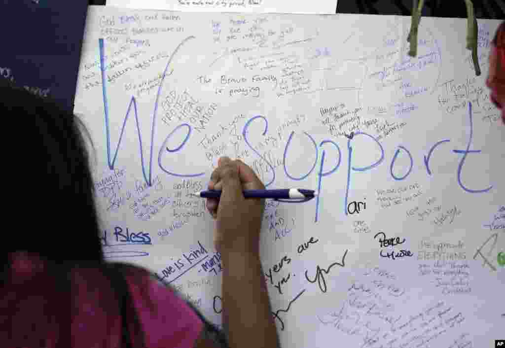 Jasmine Ruiz writes a note at a makeshift memorial in front of the police department in Dallas, July 9, 2016. Five police officers were killed in a shooting in downtown Dallas on Thursday.