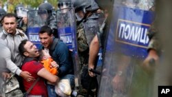 靠近希臘邊界的移民要求馬其頓防暴警察給他們通過