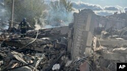 ARCHIVO - En esta imagen, proporcionada por la oficina de prensa de la presidencia ucraniana, bomberos tratan de sofocar un incendio tras un ataque ruso contra la aldea de Hroza, el jueves 5 de octubre de 2023, cerca de Járkiv, Ucrania.