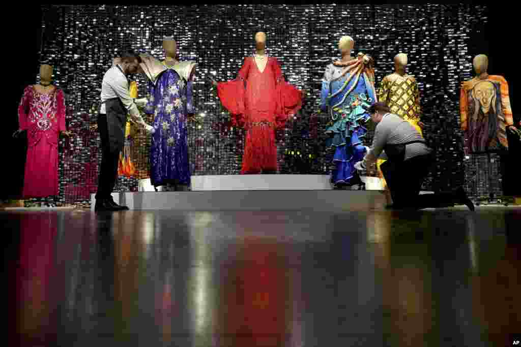 Art handlers arrange costumes during a photo opportunity ahead of the Barry Humphries: The Personal Collection sale at Christie's auction rooms in London. Items belonging to the late Australian comedian are to be auctioned February 13 in a sale estimated at 2 million to 4 million pounds ($2.49 million to $4.98 million).