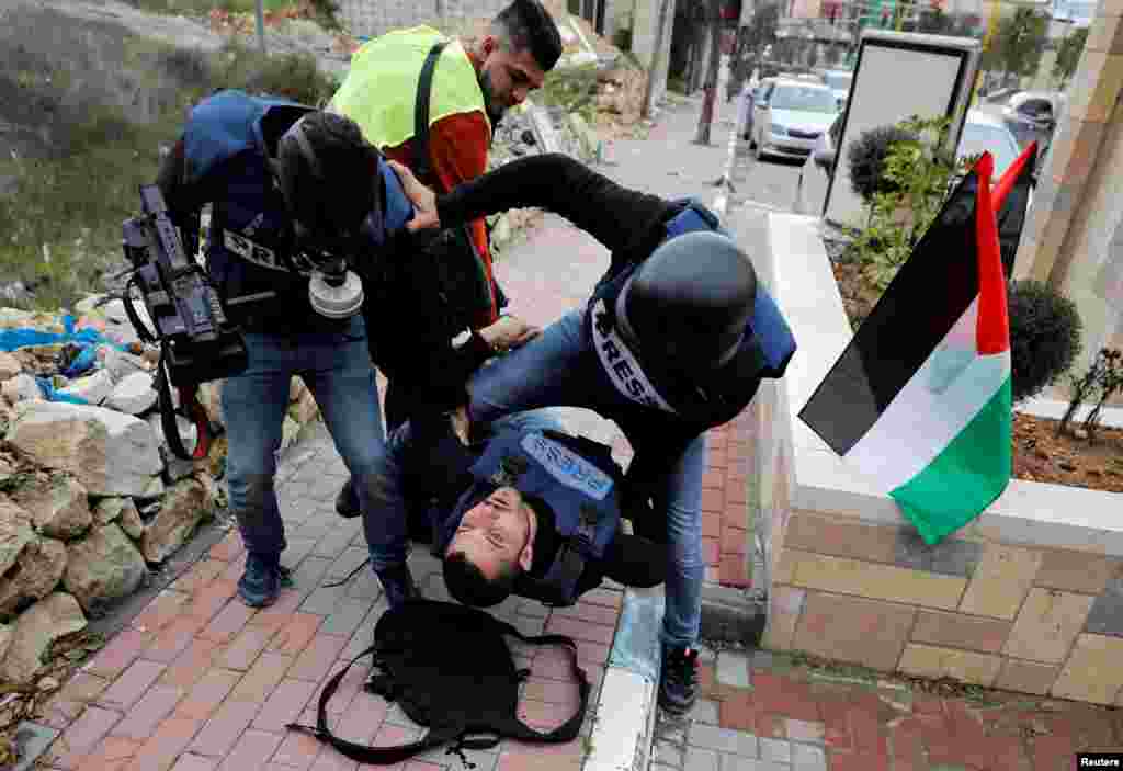A wounded Palestinian photojournalist is evacuated during an anti-Israel protest against the U.S. President Donald Trump's Middle East peace plan, in Hebron in the Israeli-occupied West Bank.