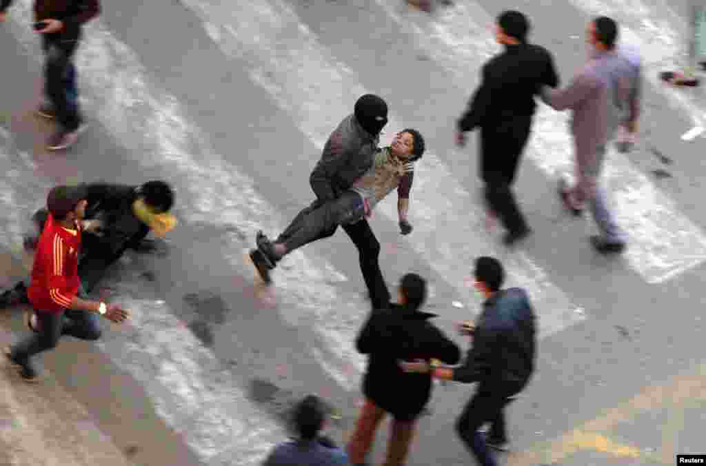 Protesters flee from tear gas fired by riot police during clashes after protesters removed a concrete barrier at Qasr al-Aini Street near Tahrir Square in Cairo, Egypt, Jan. 24, 2013.