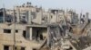 Palestinians inspect the site of Israeli strikes in Khan Younis