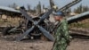 A pro-Russian rebel walks by a burnt-out plane at the destroyed airport in Luhansk, eastern Ukraine, Sept. 14, 2014. 