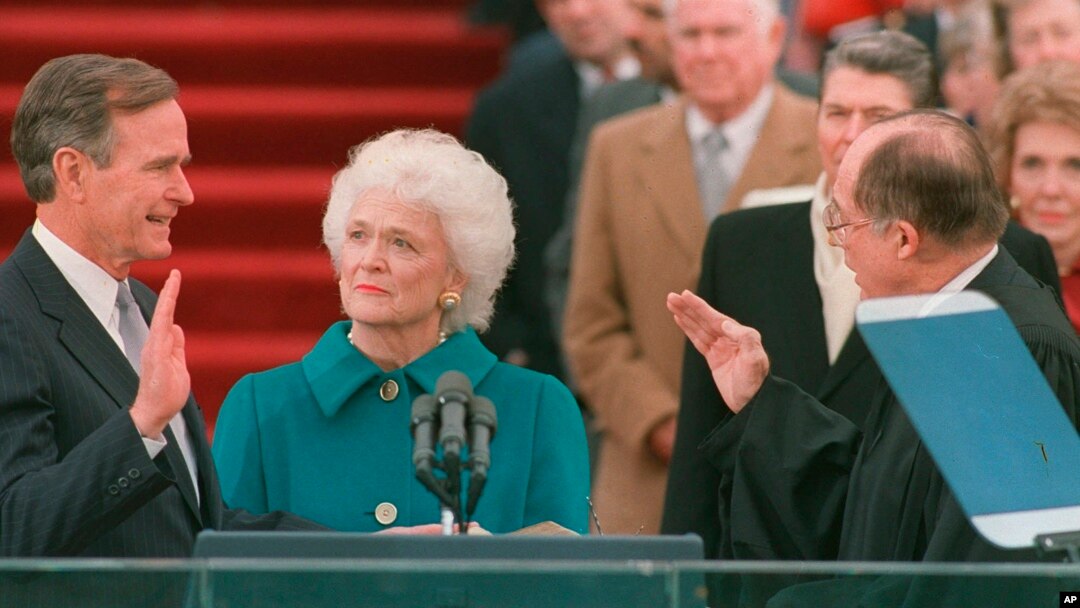 En esta foto del 20 de enero de 1989, George H.W. Bush jura al cargo como presidente número 41 de Estados Unidos ante el presidente de la Corte Suprema, William Rehnquist, mientras la primera dama Barbara Bush sostiene la Biblia.