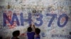 孩子们在吉隆坡国际机场的马航MH370航班的平安祝福墙上写下自己的祝愿。（2014年6月14日）