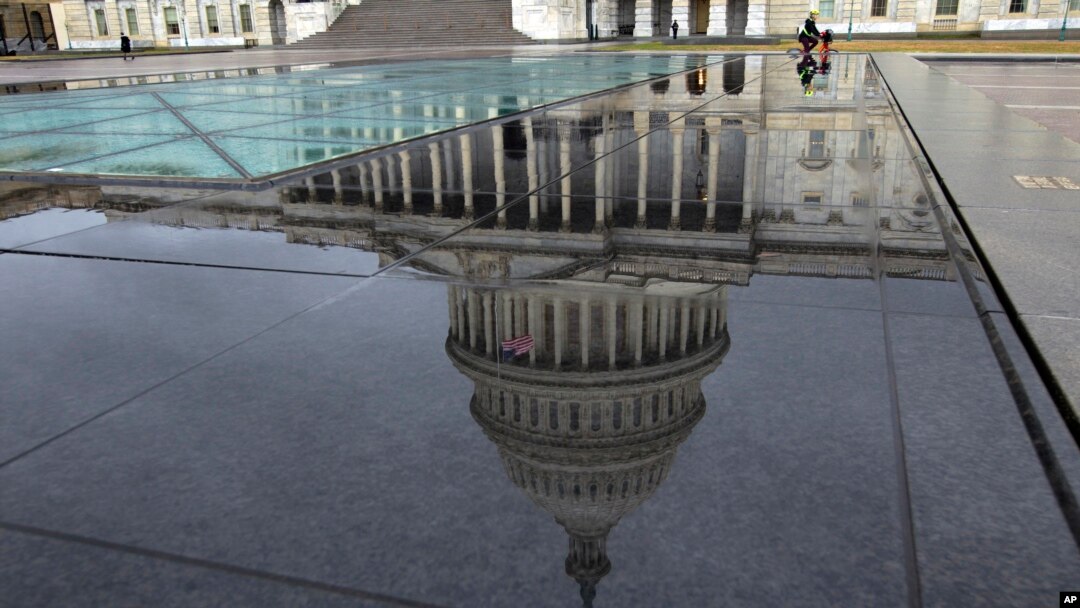 The U.S. Capitol is seen reflected after rain in Washington, Dec. 21, 2018.
