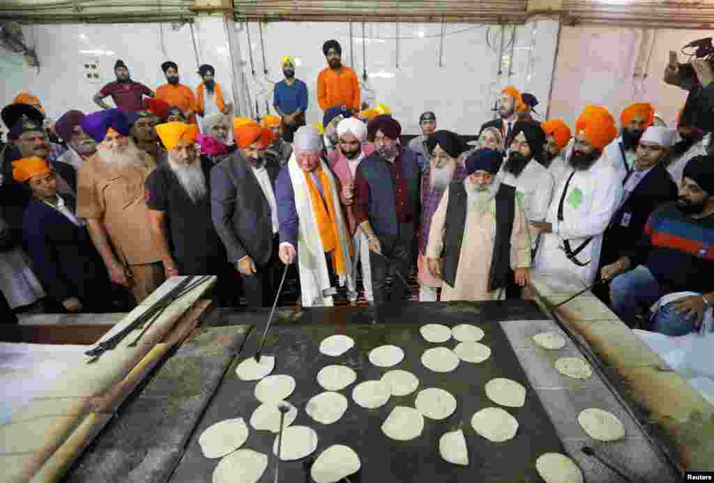 Britain's Prince Charles prepares bread at a community kitchen during his visit to a Gurudwara (Sikh temple) in New Delhi, India.