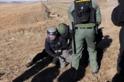 A protester is arrested next to the pipeline route during a protest against the Dakota Access pipeline near the Standing Rock Sioux Reservation in St. Anthony, N.D., Nov. 11, 2016.
