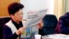 杨秀珠在浙江省温州市开会期间读报纸。（2001年12月29日资料照）