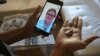 FILE - Public health nurse Peggy Cooley of the Tacoma-Pierce County Health Department, seen on the phone screen, uses Skype video to remotely monitor a patient taking antibiotics for tuberculosis at home in Lakewood, Wash, March 15, 2018. 