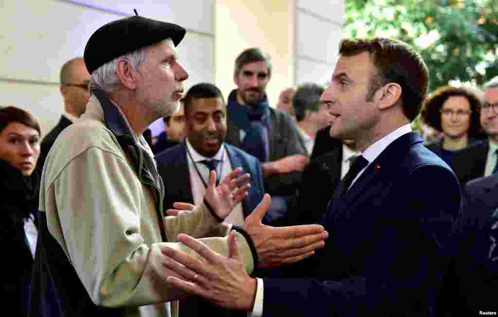 French mathematics teacher Pierre Coste speaks with President Emmanuel Macron about the government's pensions overhaul at the Beaumont Palace in Pau.