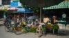 FILE - Street vendors sell vegetables on a street in Shwebo township in Sagaing region, Myanmar, Oct. 10, 2021.