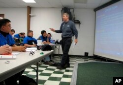 In this June 30, 2009 file photo, Larry Wostenberg teaches an engine management systems class at the WyoTech technical school, which was operated by Corinthian Colleges Inc,