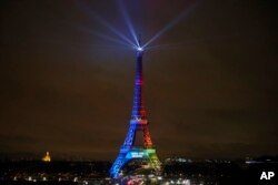 FILE - The Eiffel Tower is lit with colors for the Paris 2024 bid during the launch of the international campaign of the French capital as candidate for the 2024 Olympic summer games, in Paris, France, Feb. 3, 2017.