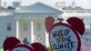 FILE - Protesters gather outside the White House in Washington to protest President Donald Trump's decision to withdraw the United States from the Paris climate change accord, June 1, 2017.
