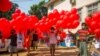 Anti-coup protesters hold red balloons carrying leaflets with various messages before releasing them during a gathering, in Yangon, Myanmar, March 24, 2021.