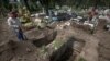 FILE - A worker digs tombs in the COVID-19 section of the cemetery of San Lorenzo Tezonco Iztapalapa on the outskirts of Mexico City, Sept. 1, 2020.