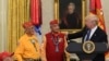 President Donald Trump, right, speaks about Sen. Elizabeth Warren, D-Mass., during a meeting with Navajo Code Talkers including, from left, Fleming Begaye Sr., Thomas Begay, and Peter MacDonald, in the Oval Office of the White House in Washington, Monday,