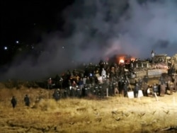 FILE - In this Nov. 20, 2016 file photo, provided by Morton County Sheriff's Department, law enforcement and protesters clash near the site of the Dakota Access pipeline in Cannon Ball, N.D.