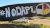 A banner protesting the Dakota Access oil pipeline is displayed at an encampment near North Dakota's Standing Rock Sioux reservation, Sept. 9, 2016. 