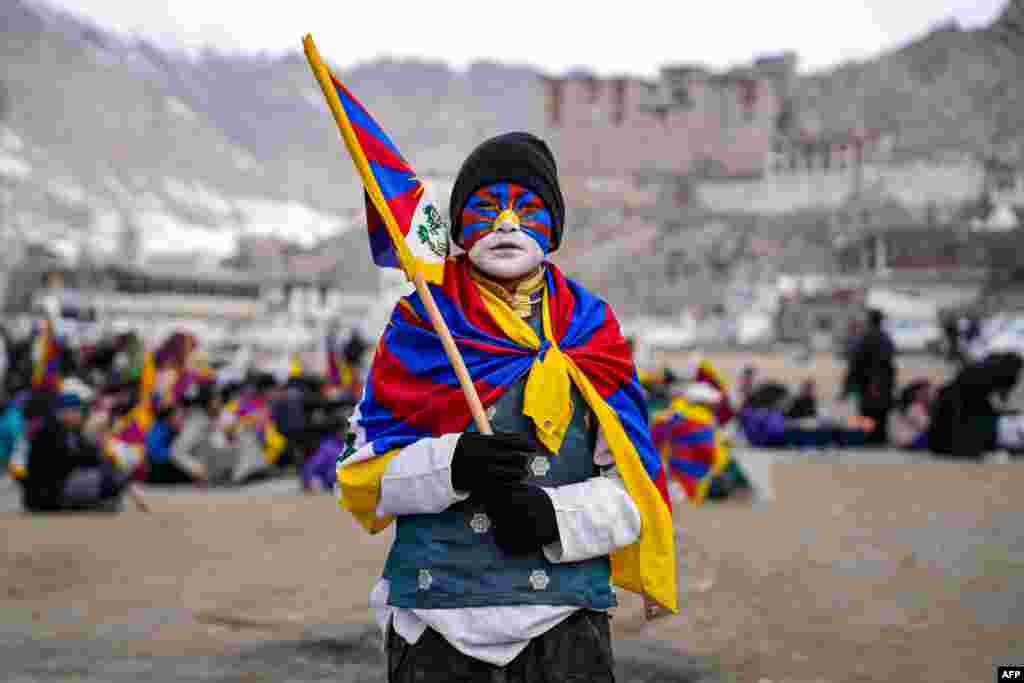 Um jovem com o rosto pintado com as cores da bandeira tibetana participa numa manifestação para assinalar o Dia da Revolta das Mulheres Tibetanas para comemorar a revolta de 1959 contra a ocupação chinesa do Tibete, no Polo Ground em Leh.