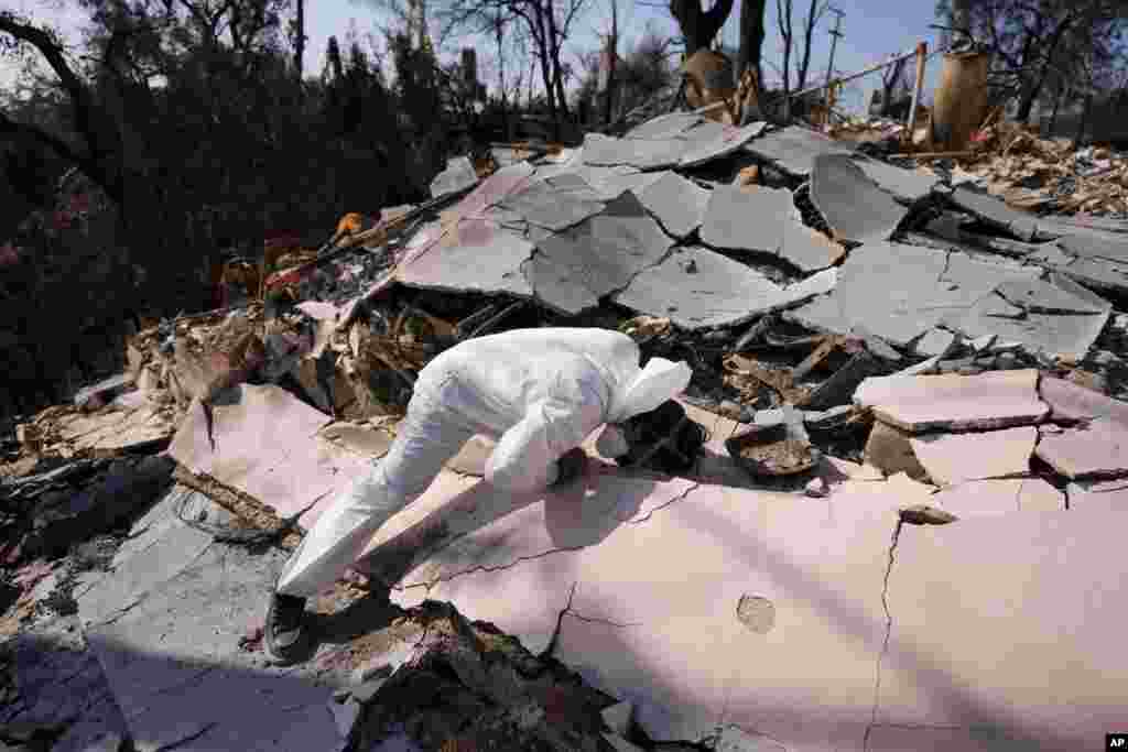 John Borbone searches through his fire-ravaged property after the Palisades Fire in the Pacific Palisades neighborhood of Los Angeles, California.